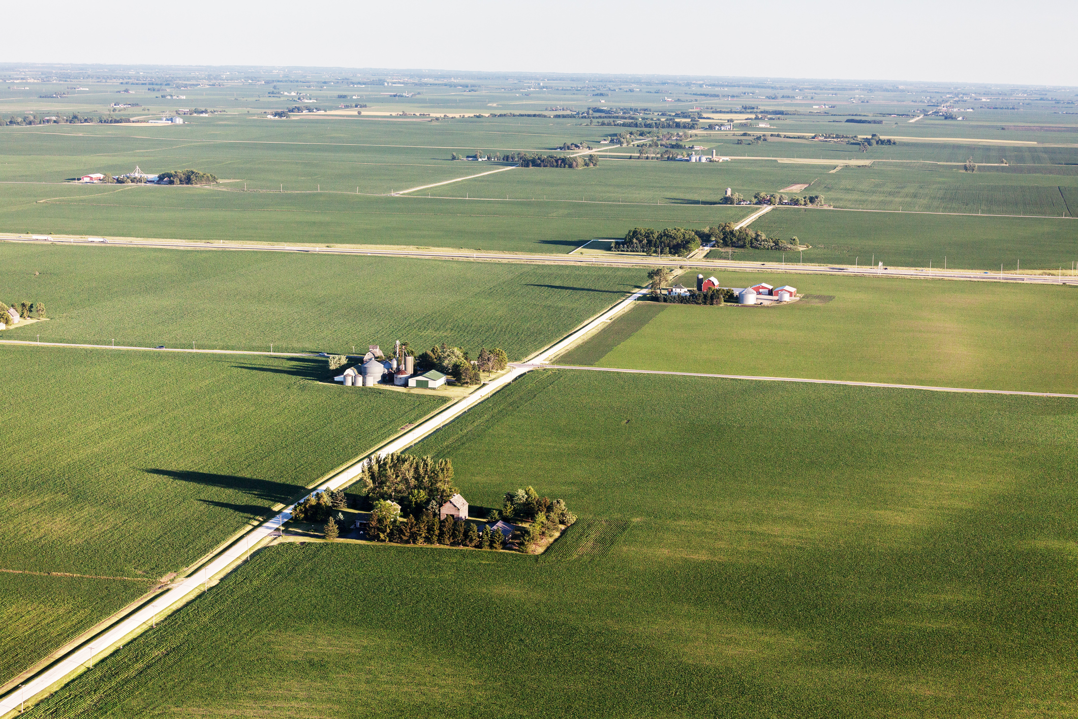 Aerial view of Farmland in Northern Illinois. Late afternoon  in June. Farms, highway, country road and crop fields. (Aerial view of Farmland in Northern Illinois. Late afternoon  in June. Farms, highway, country road and crop fields., ASCII, 117 comp